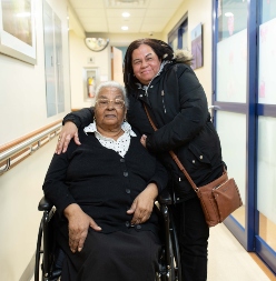 Older adult patient poses with daughter at hospital
